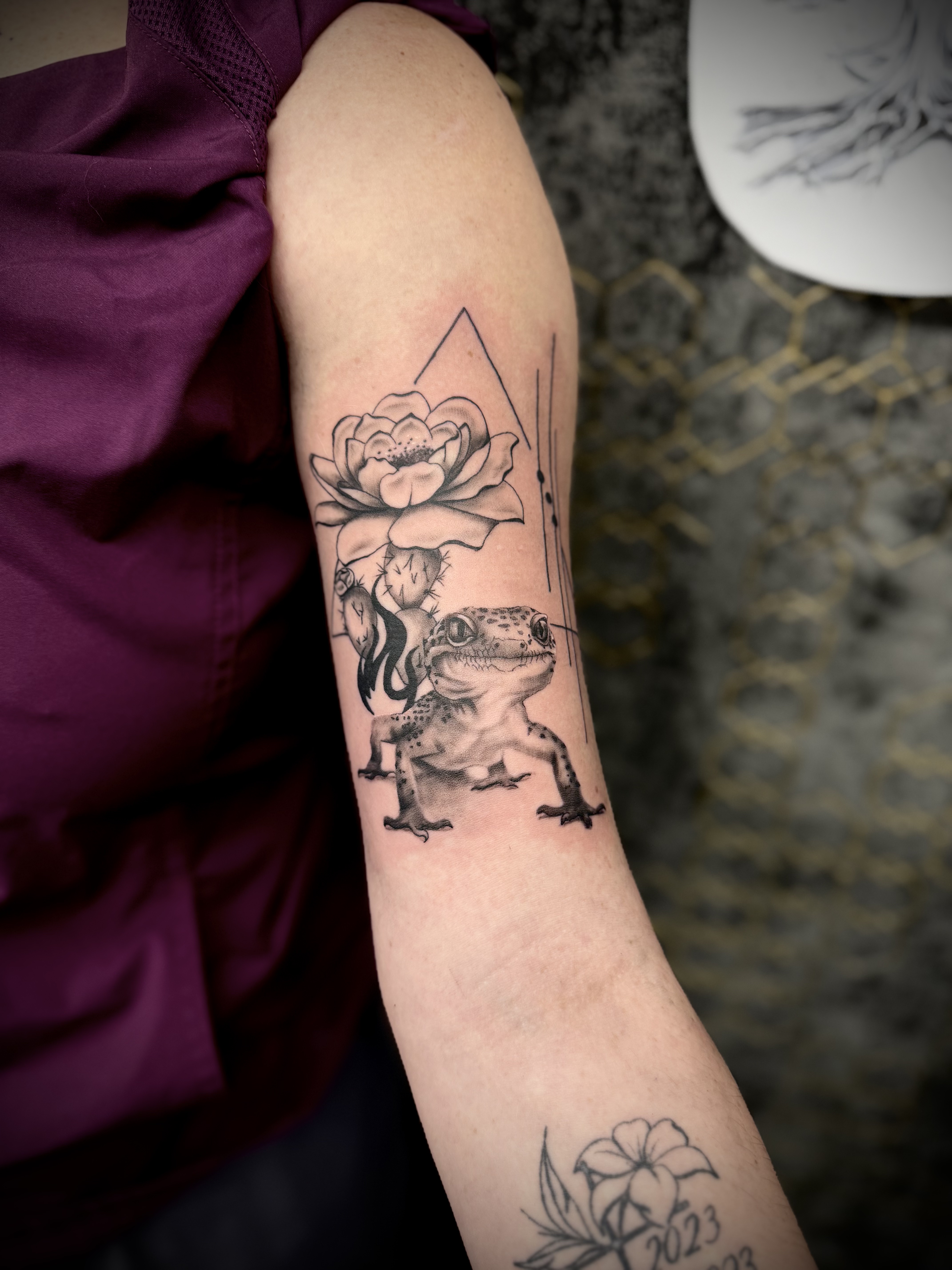 Tatouage symbolique réalisé chez L'Ascendant — gecko et fleur de lotus