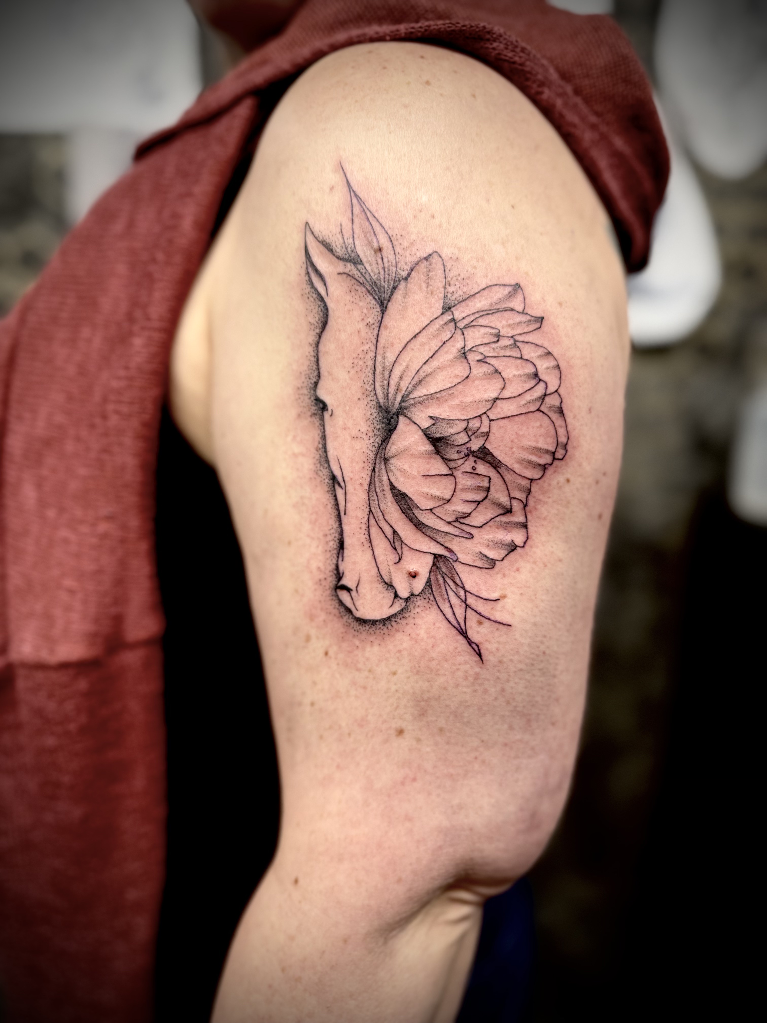Tatouage symbolique réalisé chez L'Ascendant — cheval et fleur