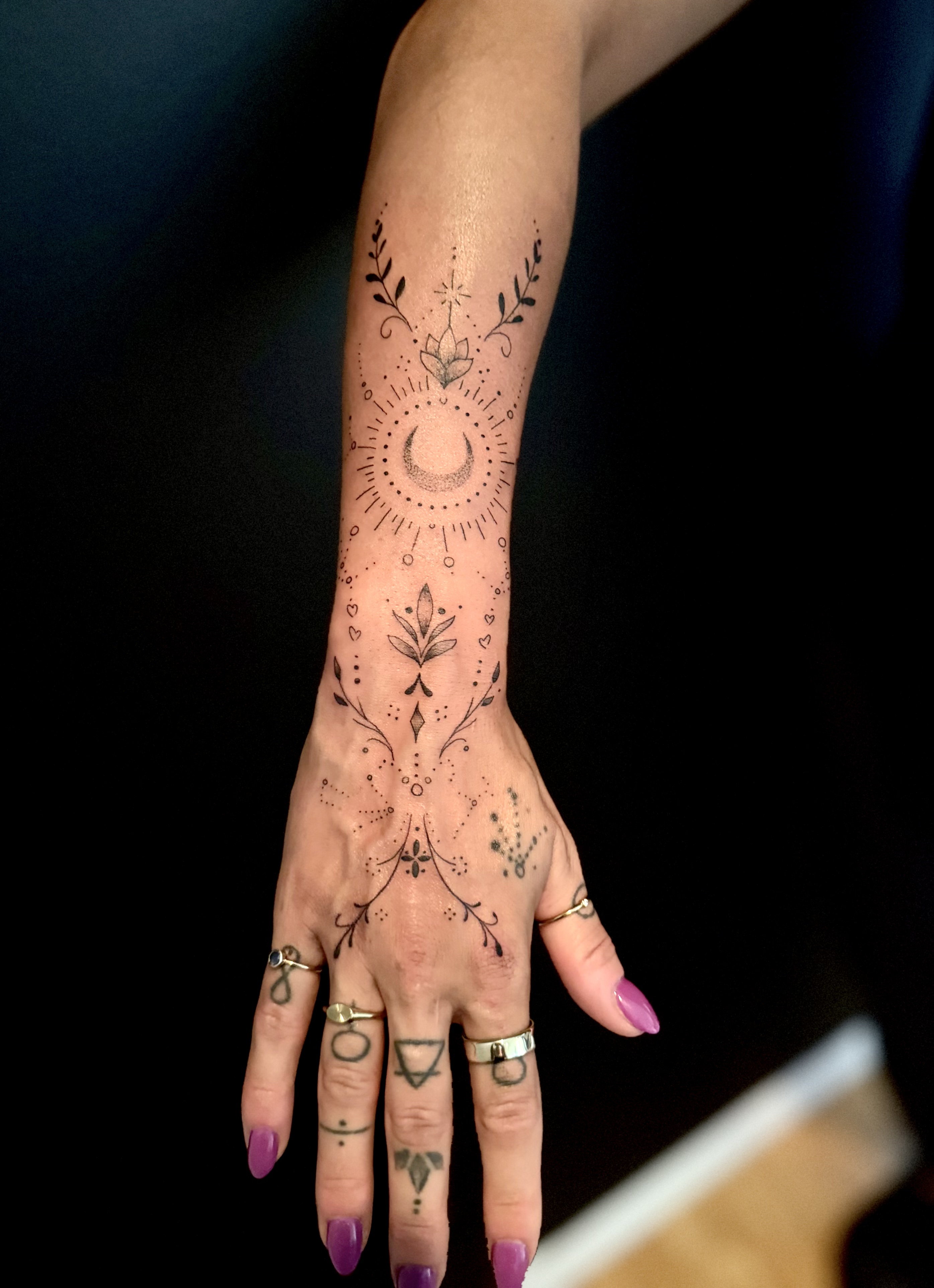 Tatouage symbolique réalisé chez L'Ascendant — soleil, lune et lotus